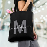 Tote Bag Monogramme de nom de script moderne tendance noir<br><div class="desc">Sac fourre-tout élégant et tendance à monogramme personnalisé avec un nom en écriture moderne noir. Ajoutez une touche de sophistication à votre style quotidien avec ce sac fourre-tout chic. Doté d'une initiale grise élégante centrée sur un fond noir net, avec un design épuré et moderne sur les deux côtés, ce...</div>