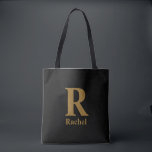 Tote Bag Monogramme de nom minimaliste moderne or/noir<br><div class="desc">Simple,  confiant et un peu chic sans en faire trop. L'initiale surdimensionnée fait tout le travail,  tandis que le nom en dessous le rend personnel. Cela ressemble à quelque chose que vous garderiez vraiment dehors,  car cela a l'air juste où qu'il atterrisse.</div>