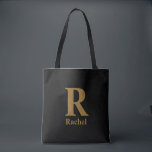 Tote Bag Monogramme de nom minimaliste moderne or/noir<br><div class="desc">Simple,  confiant et un peu chic sans en faire trop. L'initiale surdimensionnée fait tout le travail,  tandis que le nom en dessous le rend personnel. Cela ressemble à quelque chose que vous garderiez vraiment dehors,  car cela a l'air juste où qu'il atterrisse.</div>