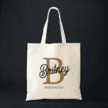 Tote Bag Monogramme moderne Nom Black Gold Script Bridesmai<br><div class="desc">Le Sac fourre-tout moderne Elegant Monogram Name Black Gold Script allie sophistication et fonctionnalité. Ce fourre-tout est doté d'un élégant tissu noir orné d'élégants monogramming de script doré, ce qui le rend à la fois élégant et personnalisé. L'intérieur spacieux est parfait pour l'essentiel quotidien, tandis que les poignées robustes assurent...</div>