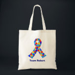 Tote Bag Nom de l'équipe Bleu ruban de Sensibilisation sur<br><div class="desc">Sac fourre-tout ruban de Sensibilisation sur l'autisme personnalisé pour les amis autistes ou la famille. Un cadeau de père ou de mère autiste cool qui peut être personnalisé avec n'importe quel texte sous le ruban de la pièce de puzzle de bleu, jaune et rouge. Un joli syndrome d'Asperger est présent....</div>