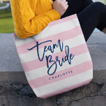 Tote Bag Pastel Pink et White Stripes Blue Team Bride<br><div class="desc">Sac fourre-tout All-Over-Print avec les mots "Team Bride" en écriture tendance bleue contre un arrière - plan motif pastel rose et blanc rayures. Parfait pour les mariages pour les demoiselles d'honneur, la servante d'honneur et la fille aux fleurs. Pour d'autres couleurs et éléments correspondants, voir ici https://www.zazzle.com/collections/119250194970828530?rf=238364477188679314 Personnalisez-le en remplaçant...</div>