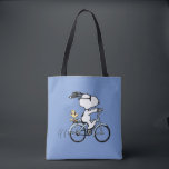 Tote Bag Peanuts | Snoopy & Woodstock Bicycle<br><div class="desc">Pedal into style and classic charm with this adorable cream canvas tote bag, featuring Snoopy and Woodstock on a bicycle! This fun tote showcases a delightful line-art illustration of Snoopy, wearing sunglasses, happily riding a vintage-style blue bicycle with Woodstock perched safely behind him. The dashed lines behind the back wheel...</div>