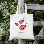 Tote Bag Rouge Aquarelle Ladybugs Personnalisé<br><div class="desc">Ce sac fourre-tout présente trois coccinelles sucrées dans des aquarelles rouges et charbonneuses. Coordonné avec notre collection de vêtements et accessoires Aquarelle Ladybug. Personnaliser avec un nom si vous le souhaitez - fait une fête parfaite pour les fêtes d'anniversaire des filles!</div>