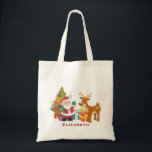 Tote Bag Santa and Reindeer par Christmas Tree with Present<br><div class="desc">Une jolie illustration avec l'esprit de fête. Le Père Noël portant son sac cadeau et saluant. Son ami renne à ses côtés, suspendu par un sapin décoré, avec des cadeaux tout autour. Placez-vous sur un arrière - plan rouge avec des cercles fantaisistes. Design festif et gai. Personnalisez avec un nom...</div>