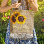 Tote Bag Tournesols toile de jute dentelle mariage mère de<br><div class="desc">Sac élégant rustique pour mariage d'été ou d'automne, stylé pour la mère de la mariée / mère du marié / demoiselle d'honneur / témoin / petite fille aux fleurs sur faux simili burlap beige avec de beaux bouquets de tournesols jaunes dorés et bordures en dentelle blanche sur les deux faces....</div>