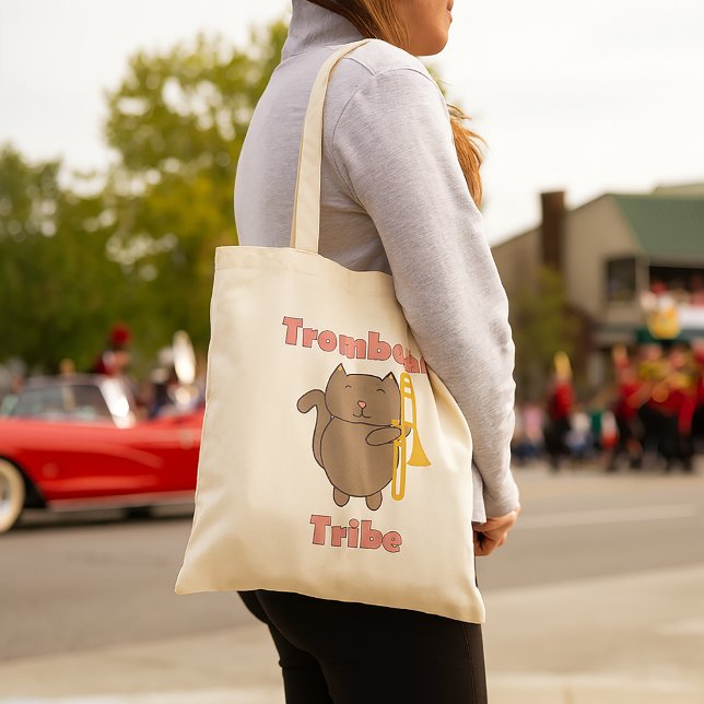 Tote Bag Trombone Tribe Lettres Roses Chat Mignon (A tote bag with a brown cat holding a trombone and the words trombone tribe in pink letters.)