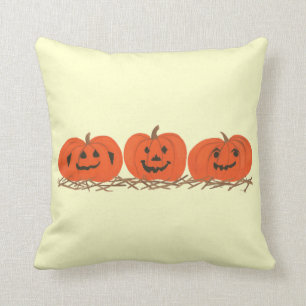 Trois citrouilles heureux dans le coussin de