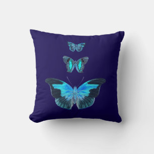 Trois papillons bleus sur un oreiller bleu foncé