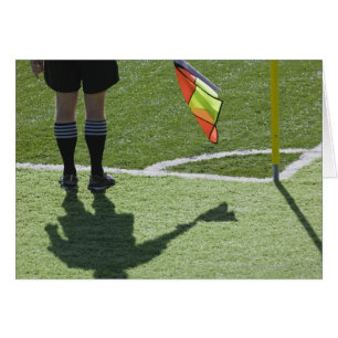 Un arbitre de football tient le drapeau.