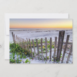 Une clôture de plage au coucher du soleil