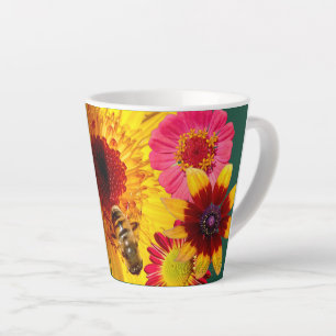 Une tasse de latte de fleur colorée et d'abeille a