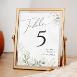Verdure et or | Numéro de table<br><div class="desc">Entrez dans un monde enchanteur avec notre verdure fantaisiste et notre or | numéro de table, parfait pour votre réception de mariage botanique printanière. Orné d'eucalyptus vert sauge et d'accents dorés, ce numéro de tableau exsude l'élégance et de fantaisie moderne. Imaginez vous promener dans un jardin d'été magique, entouré par...</div>