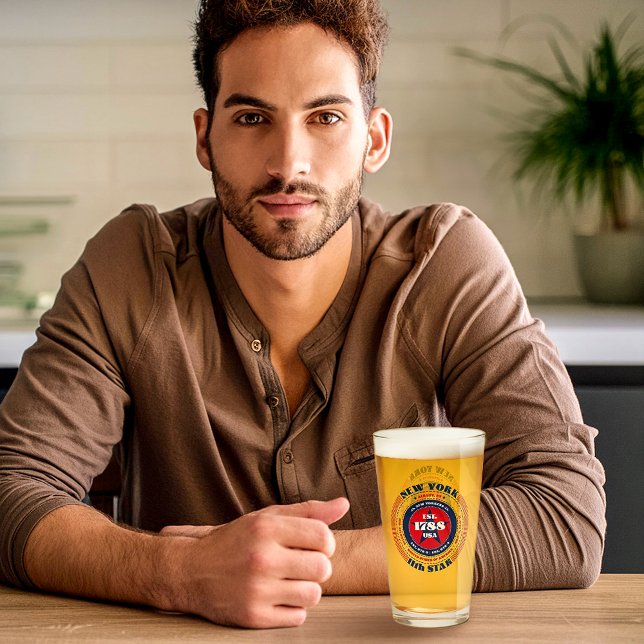 Verre Design de typographie circulaire de New York (A young man sits with the New York glass designed by The American Family.)