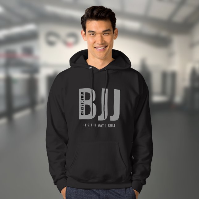 Veste À Capuche BJJ brésilien Jiu Jitsu Modifier le nom et le text (Personalized black BJJ hoodie worn by a male model in a gym)