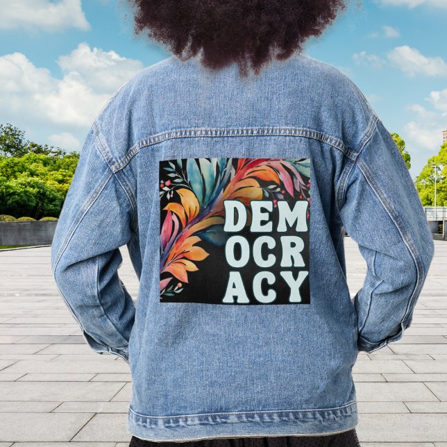 Veste En Jean Super Retro Colorful déclaration politique démocra (A stylish denim jacket with 'Democracy' in capital letters on a decorative leafy back panel)