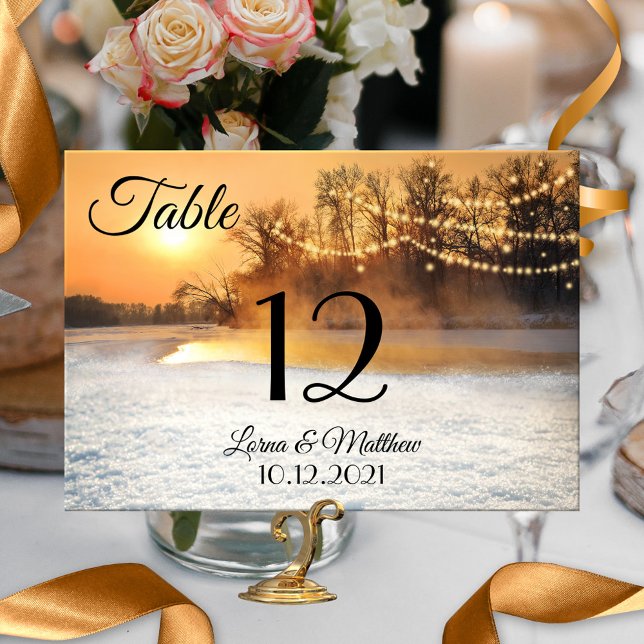 Winter Wonderland String Lights Numéro de la carte (A festive table number card featuring a winter wonderland scene at sunset with festive string lights)